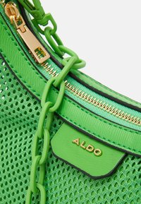 Světlý zelený kabelka ALDO s mřížkovou texturou, zlatým zipem, zeleným plastovým řetízkem a zlatým logem značky na malé kožené klapce.