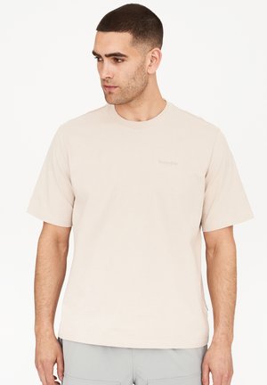Lys beige bomulds t-shirt med rund halsudskæring, korte ærmer og et subtilt brandlogo i midten. Glat tekstur, klassisk pasform.