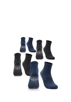 Acht Knöchelsocken in Marineblau und Dunkelgrau mit weißen rutschfesten Sohlen, angeordnet in versetzten Reihen.