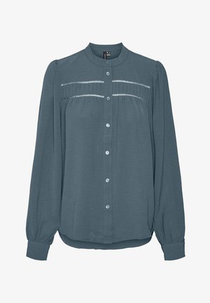 Dlouhý rukáv tyrkysové halenky s knoflíkovou légou vpředu, kulatým límečkem, nařaseným sedlem s krajkovými detaily přes hrudník a manžetovými rukávy.