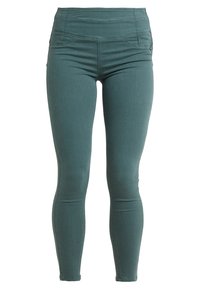 Legginsy slim fit w kolorze teal, wykonane z rozciągliwego materiału bawełnianego. Posiadają wysoki stan i subtelne detale przeszyć. Brak widocznych kieszeni.