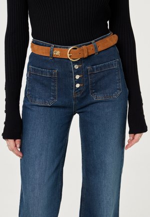 Hoge taille donkerdenim jeans met een sluiting van vijf knopen, twee zijzakken en een bruine suede riem met een ronde gouden gesp.