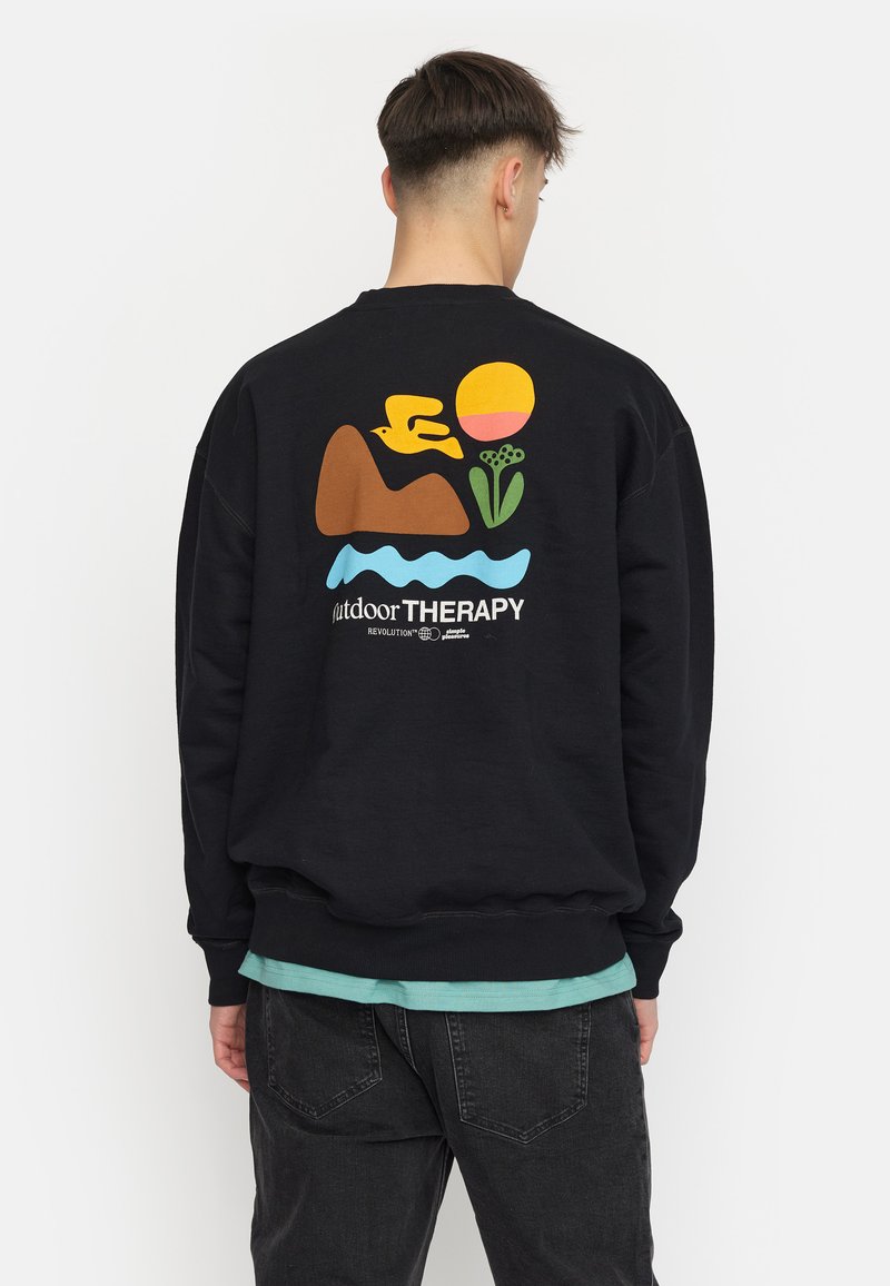 Zwart sweatshirt met kleurrijk grafisch ontwerp: een vogel, berg, zon, bloem en watermotief. Losse pasvorm met geribde manchetten en zoom.