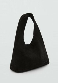 Borsa a mano in suede nero con un manico unico e arrotondato, caratterizzata da una texture morbida e una forma pulita e minimalista.