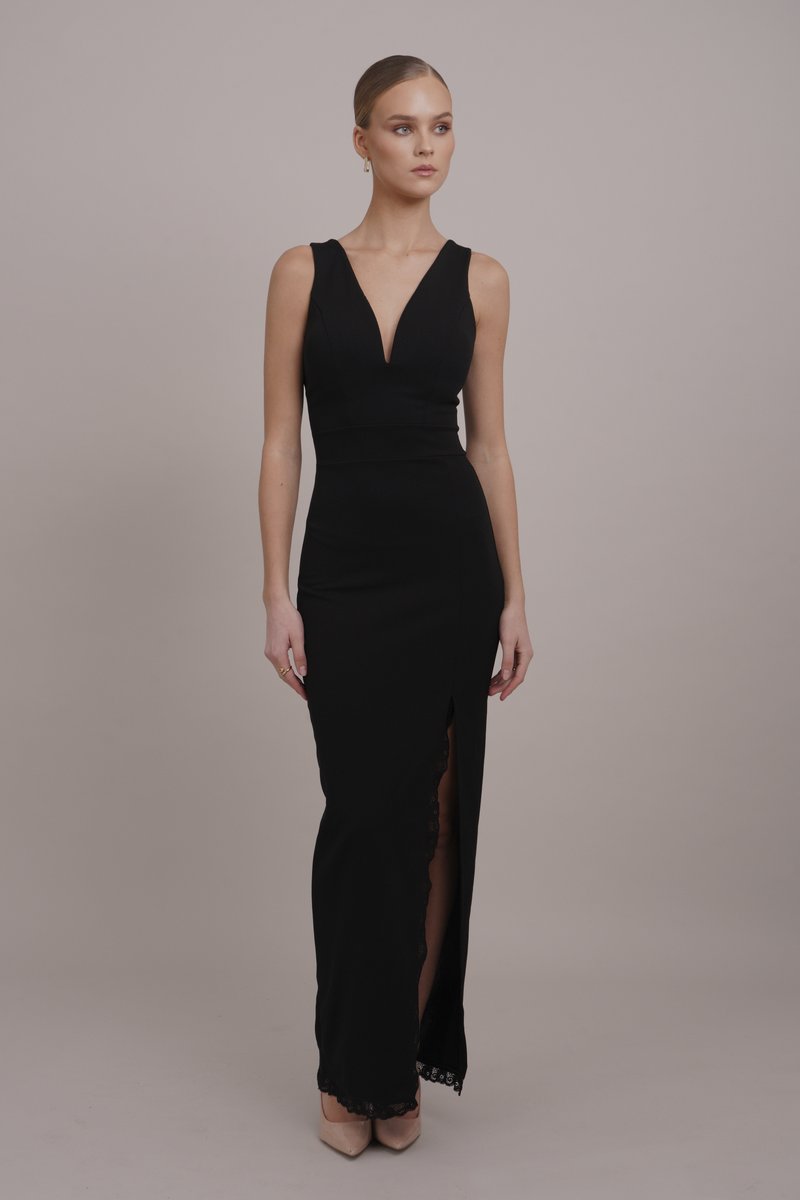 Black evening gown with a deep V-neckline, fitted bodice, and floor-length skirt featuring a thigh-high slit and lace trim at the hem.