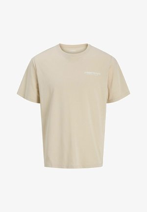Camiseta beige de manga corta con cuello redondo, con un pequeño logo de texto blanco que dice "JJ Rebel Philosophy" en el pecho izquierdo.