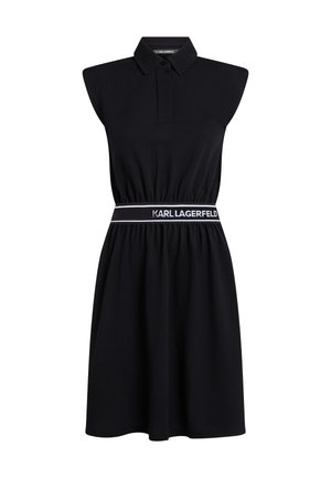 Juodas berankovis suknelė su polo apykakle, elastinga juosmens juosta su baltu logotipu ir laisvu siluetu, pasiekiančiu iki vidurio šlaunų.