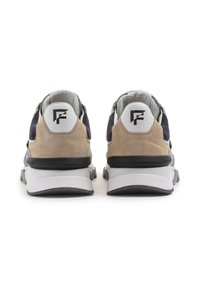 Elegante Sneaker aus einer Kombination von hellbraunem Wildleder und navyfarbenem Stoff, mit einem weißen Logo an der Ferse und einer strukturierten schwarz-weißen Sohle.
