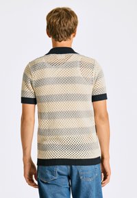 Kortärmad, randig stickad polo i beige och marinblå, med en andasöppnad vävstruktur och ribbad krage och manschetter.