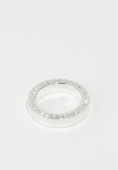 Anillo de plata con una banda lisa, que presenta una fila circular de piedras preciosas claras alrededor del borde exterior. Diseño sencillo y moderno.