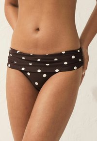 Chiloți de bikini maro cu buline, având un brâu adunat și o textură netedă, concepuți pentru o siluetă ajustată.