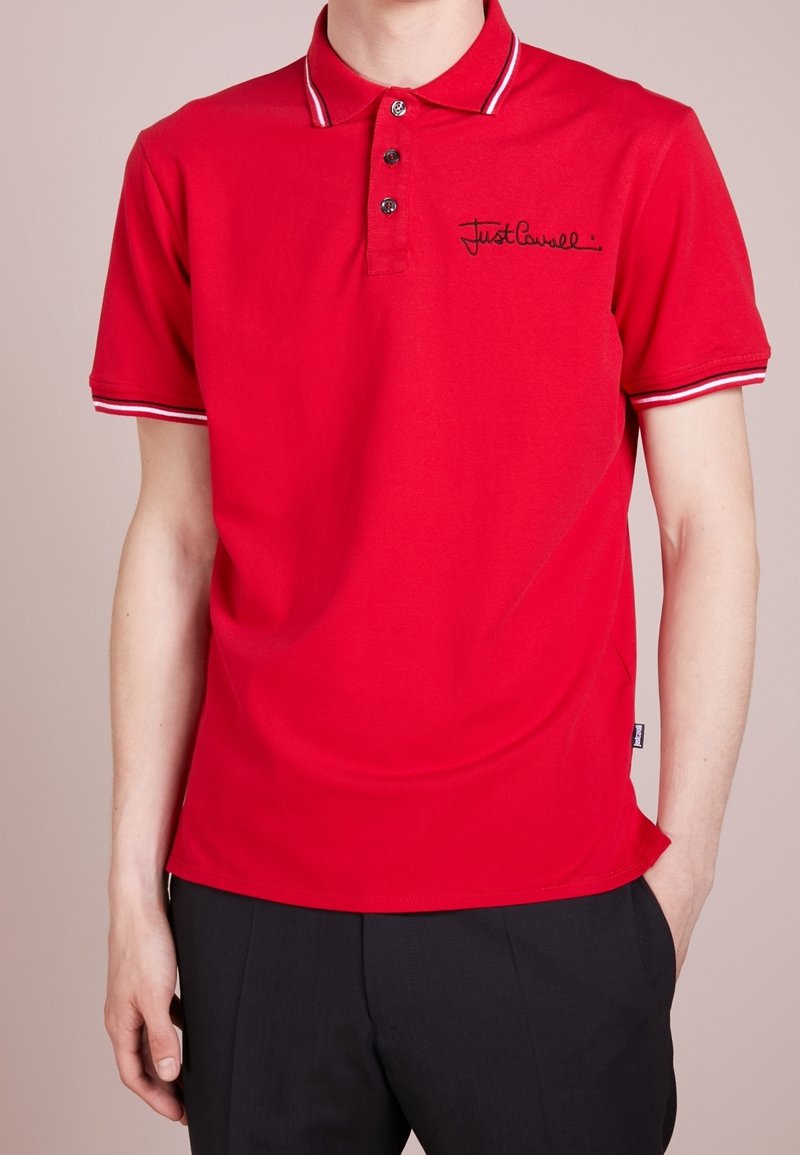 Polo rouge à manches courtes avec col et poignets rayés blancs et noirs, boutons noirs et logo "Just Cavalli" noir sur la poitrine.