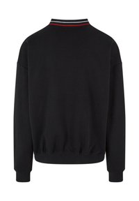 Black sweatshirt with a ribbed collar featuring a red and white stripe. Loose fit with long sleeves and a gathered hem. Smooth texture.