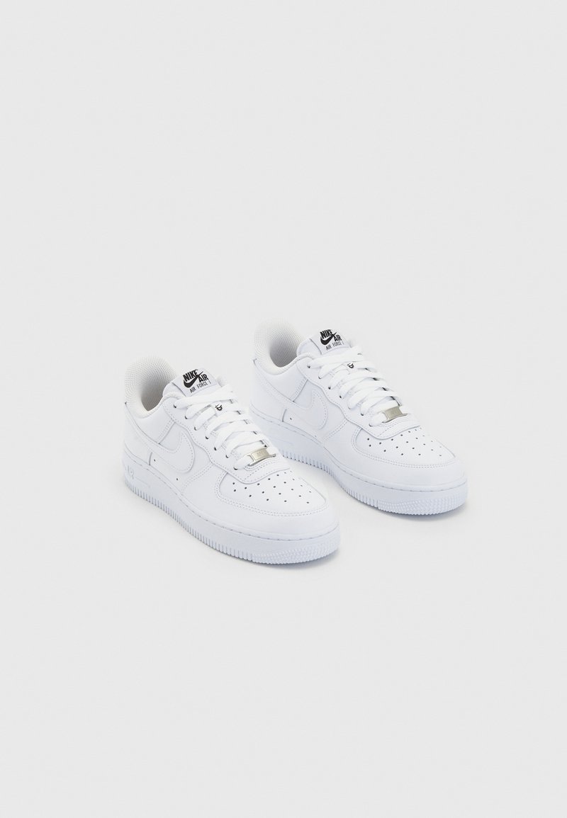 Witte leren Nike Air Force 1 sneakers met geperforeerde neus, platte veters en een rubberen zool. Voorzien van metalen accenten en branding.