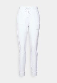 Vita mjukisbyxor i en mjuk bomullsblandning, med dragsko i midjan, smalnande ben och en logotyp på vänster lår.