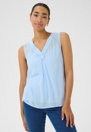 Top sans manches bleu clair avec un design en V, présentant un petit détail de bouton et une texture fluide et transparente. Assorti à un jean bleu.