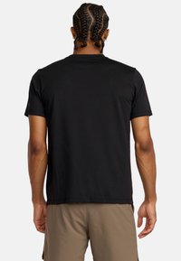 Schwarzes Baumwoll-T-Shirt mit kurzen Ärmeln und rundem Halsausschnitt. Weicher Stoff und lockere Passform, ohne sichtbare Muster oder Grafiken.