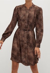 Robe marron à imprimé léopard avec manches longues, devant boutonné et taille ceinturée. Texture douce et silhouette fluide.