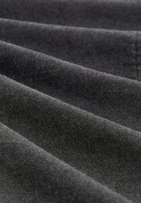 Donkergrijze stof met een zachte textuur, voorzien van een subtiel schuin ribbelpatroon. Het materiaal lijkt glad en duurzaam.