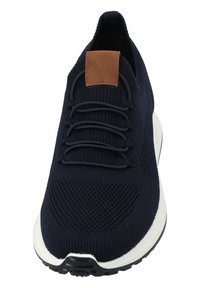 Sneaker in maglia blu navy con tomaia testurizzata, suola in gomma e un accento in pelle marrone sulla linguetta. Presenta lacci elastici per una facile vestibilità.