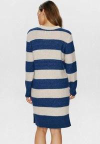 Striped sweater dress featuring horizontal navy blue and beige stripes, long sleeves, a round neckline, and side slits at the hem.