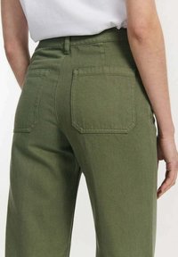 Groene katoenen broek met een rechte pijp, voorzien van twee achterzakken en een licht gestructureerde afwerking.