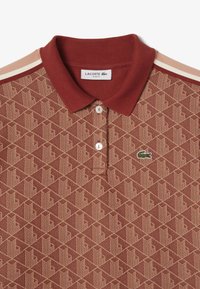 Slim fit polo shirt in bordeaux, met een getextureerd geometrisch patroon en een drieknoopsluiting. Accenten met een groen geborduurd logo.