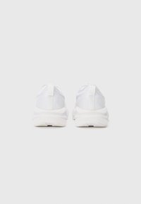 Weiße Sportschuhe mit glatter Textur, ausgestattet mit einer gepolsterten Sohle, minimalistisches Design und dezenten reflektierenden Akzenten an der Ferse.