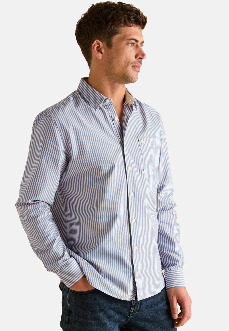 Koszula w paski w niebiesko-białym kolorze, wykonana z lekkiego materiału. Posiada kołnierzyk, kieszeń z przodu oraz zapięcia na guziki przy mankietach.