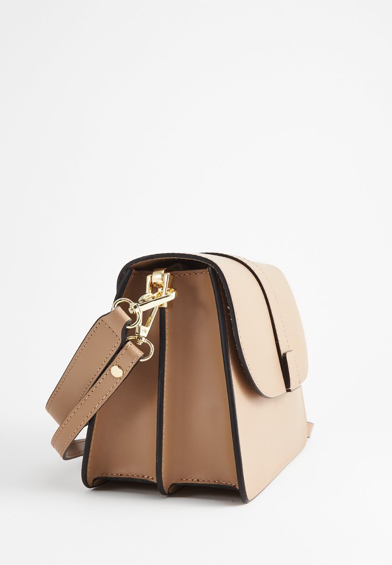 Beżowa torebka z ekoskóry o strukturalnym kształcie, z klapką, czarną podszewką i złotymi akcentami. W komplecie regulowany pasek.
