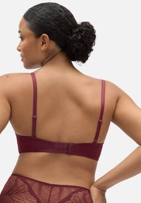 Sujeta-bra burdeos con tirantes delgados ajustables, espalda texturizada y cierre de gancho y ojo. Material suave con un diseño ceñido.