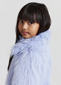 Hellvioletter Kunstpelzmantel mit flauschiger Textur, ausgestattet mit einem hohen Kragen und legerem Schnitt, getragen von einem Mädchen mit langem, dunklem Haar.