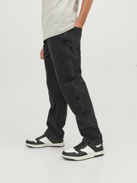 Svarta raka jeans i denim, med en klassisk femfickorsdesign och subtila sömnadsdetaljer, kombinerade med svartvita sneakers.