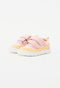 Sneaker rosa e gialla con parte superiore in suede, dotate di due pattini in velcro, suola bianca e un design testurizzato nella zona delle punte.