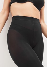 Zwarte high-waisted leggings van rekbaar stof, met een strak ontwerp en gladde textuur, een aansluitende pasvorm en geen zichtbare naden.