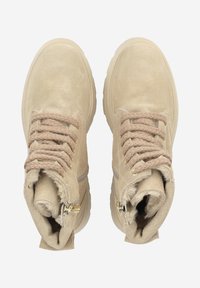 Beige Wildleder-Stiefeletten mit strukturierten Schnürsenkeln, goldfarbenen Beschlägen und einem weichen Futter am Kragen sowie Reißverschlussdetails.