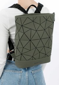 Zaino verde con motivo geometrico, dalla finitura liscia e dettagli neri, dotato di spallacci regolabili e maniglia superiore per il trasporto.