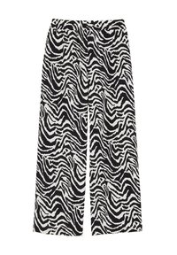 Pants širokih nogavic v črno-beli zebri, z elastičnim pasom in mehkobo teksture. Ima valovit vzorec po celotnem materialu.
