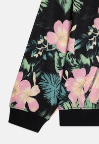 Sudadera floral con fondo negro, flores tropicales en tonos rosa y verde, puños en ribete negro y un diseño de tela texturizada.