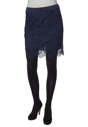 Falda de encaje marino con dobladillo en forma de ola, que presenta una cinta suave en la cintura y un intrincado patrón floral. Combinada con medias negras y zapatos de tacón.