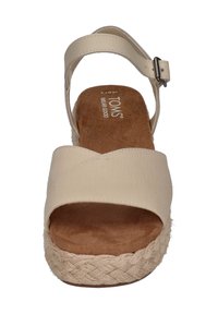 Beige espadrillesandal med en vevd tau-såle, kryssreimedesign i stoff, justerbar ankelreim og polstret fotseng.