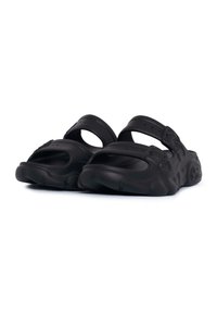 Sandales noires en caoutchouc avec deux sangles réglables et des semelles texturées, présentant une forme arrondie et épaisse ainsi qu'un dessus de pied détaillé.