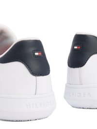 Sneakers bianche con una tomaia in pelle liscia, dettagli in blu notte sul tallone, cuciture decorative e un logo su una suola in gomma testurizzata.