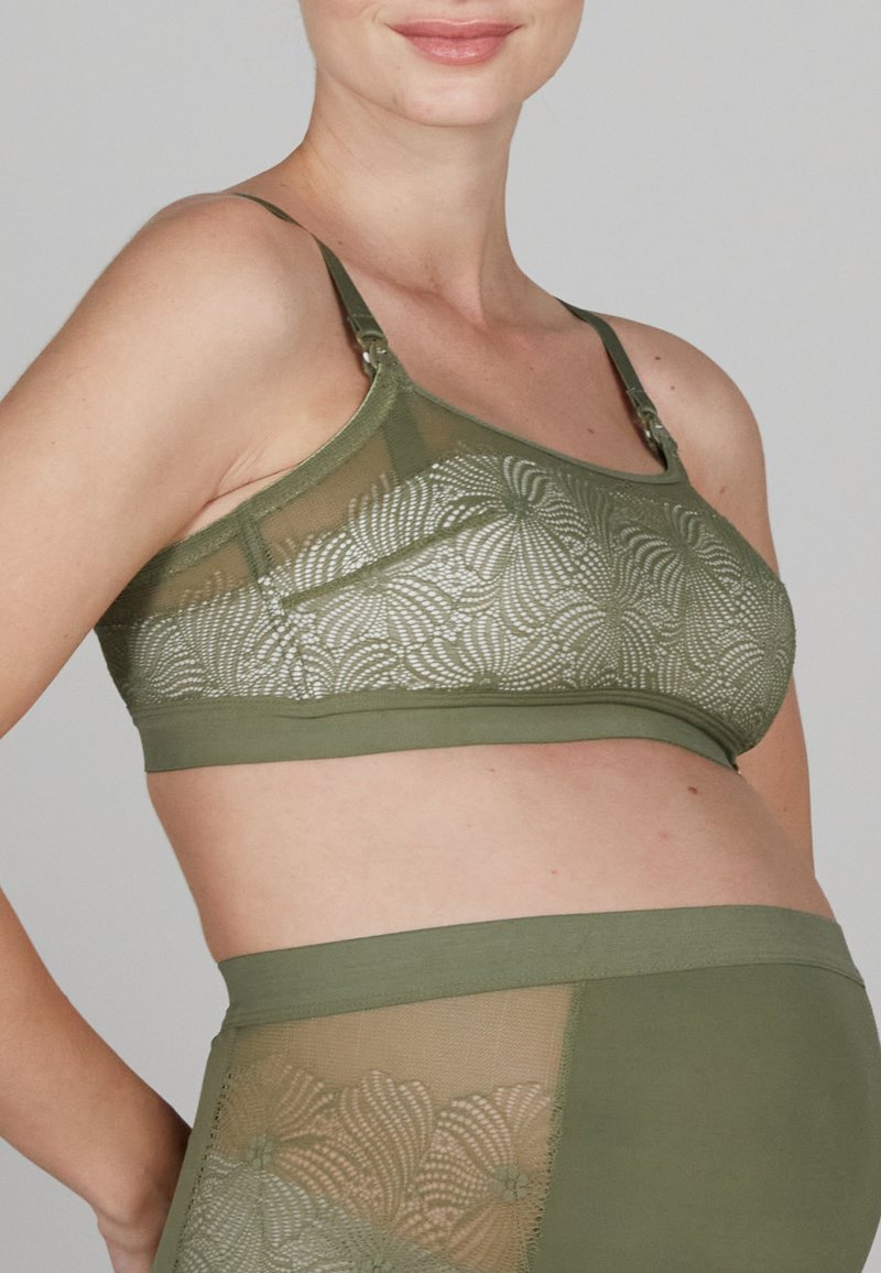 Olivengrüner BH mit transparenten Spitzeneinsätzen, die mit floralen Mustern verziert sind. Verstellbare Träger und ein glatter, weicher Bund unter der Brust.