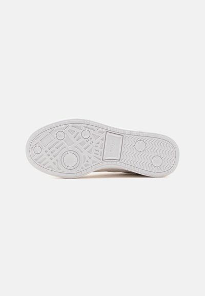Semelle blanche de sneaker avec motifs géométriques texturés et grips circulaires, avec le mot "Polo" dans une section rectangulaire près du centre.