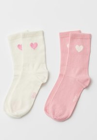 Katoenen sokken in wit en roze, met een geribbelde textuur en hartvormige ontwerpen. Witte sokken hebben roze harten; roze sokken hebben crèmekleurige harten.
