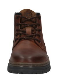Braune Lederknöchelstiefel mit schwarzer Gummisohle und dunkelbraunen Schnürsenkeln, von vorne betrachtet.