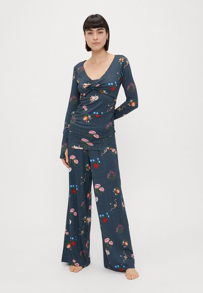 Σet λούντζ με φλοράλ σχέδιο και ναυτική ριγέ σχεδίαση. Περιλαμβάνει μπλουζάκι με βαθύ V και μακριά μανίκια, καθώς και παντελόνι με φαρδιά πόδια. Μαλακή υφή υφάσματος.