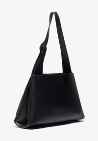 Schwarze Lederhandtasche mit dreieckiger Form, verstellbarem Schultergurt und glatter Textur. Hat einfache Nähte und minimalen Beschlag.