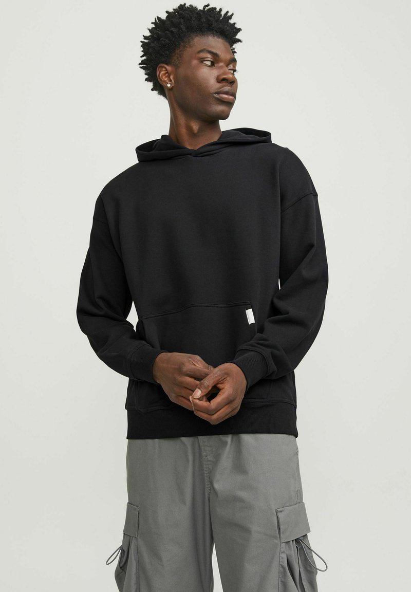 Black hoodie with a kangaroo pocket, made from soft cotton blend. Features ribbed cuffs and hem, with a subtle logo tag on the front.